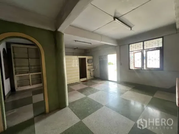 Shophouse for rent in Suan Luang, Bangkok - Ground-floor space with checker tiles, natural light and an arched doorway.