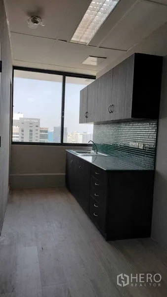 办公空间 出租或出售在Pathum Wan, Bangkok - 紧凑茶水间，带橱柜与水槽，窗外城市景观。