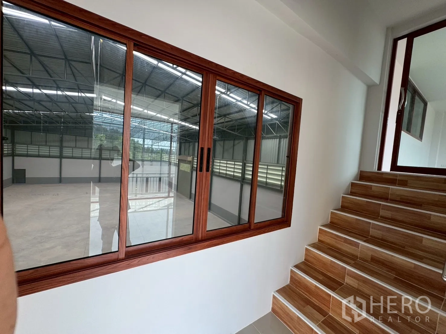 โรงงาน for sale in Mueang Samut Sakhon, Samut Sakhon - โถงทางเดินมีหน้าต่างบานเลื่อนมองเห็นพื้นโกดังและบันได