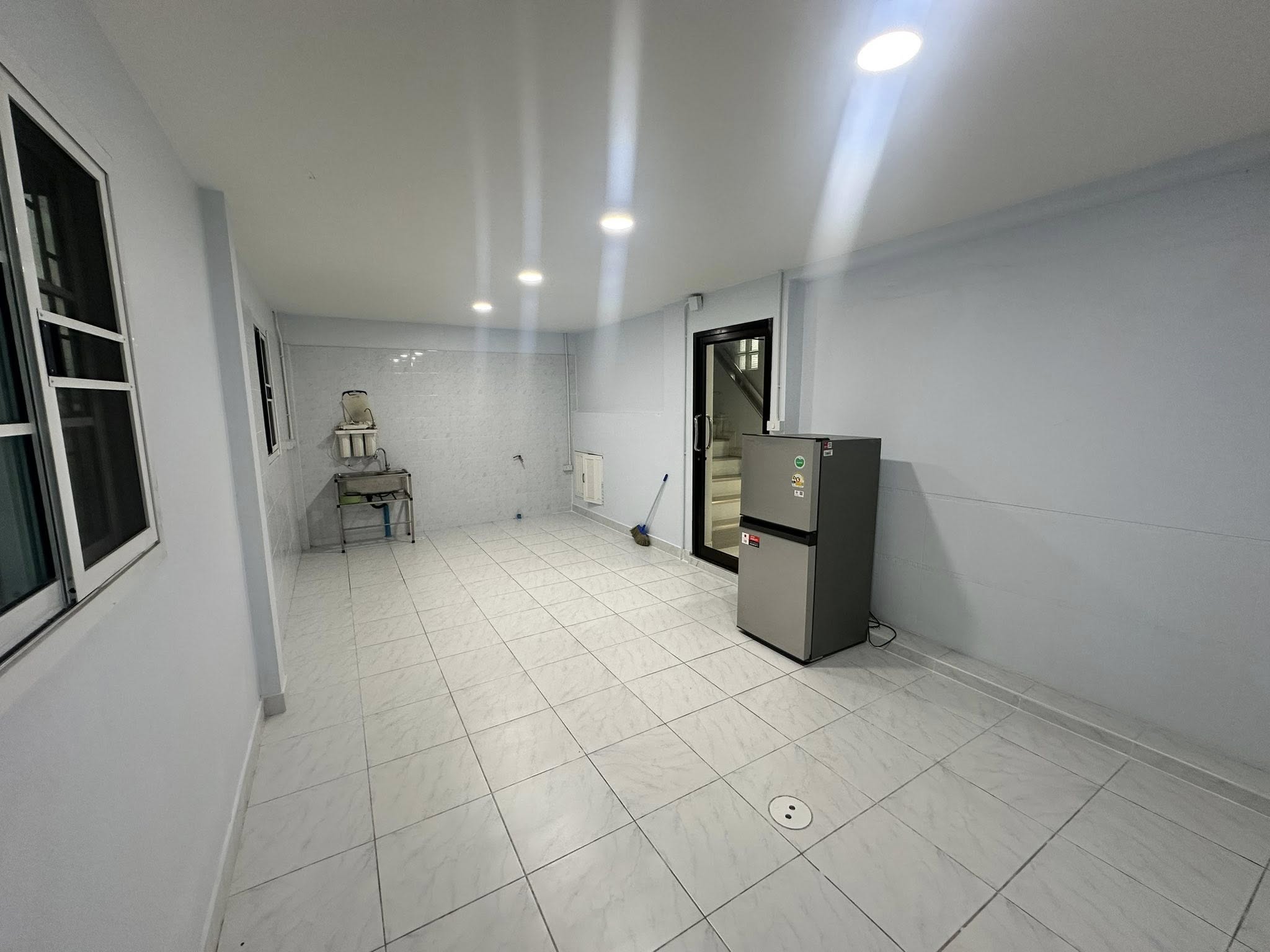 Home Office for rent in Wang Thonglang, Bangkok - Kitchen view with stainless sink, windows and recessed ceiling lights.