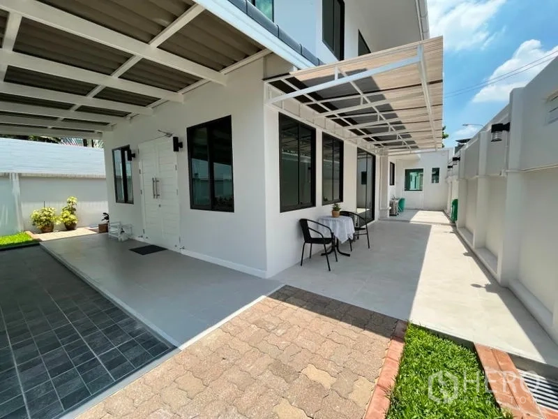 Detached House for rent in Phaya Thai, Bangkok - Side terrace under awning with seating area beside the house.