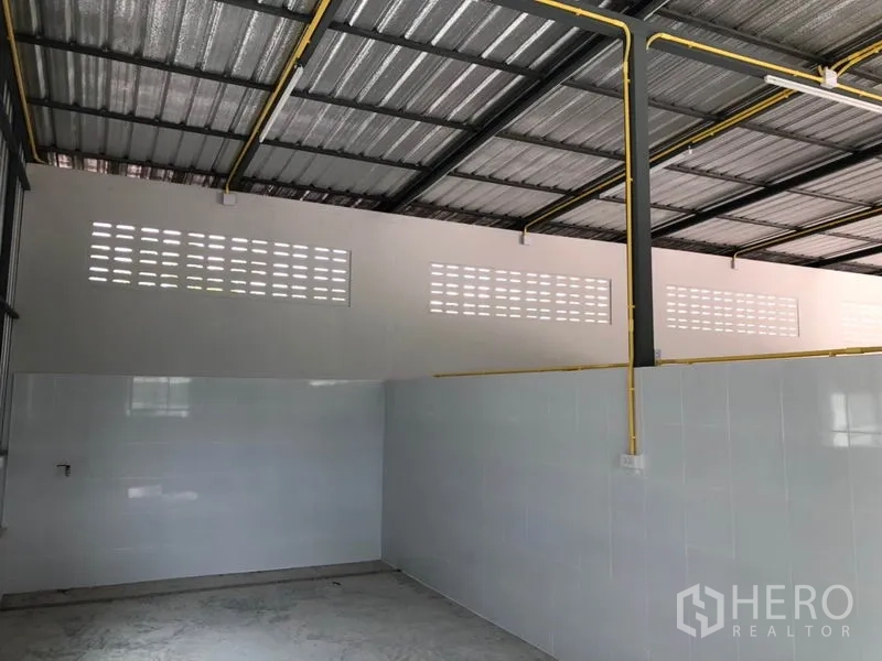 Warehouse for rent or sale in Thanyaburi, Pathum Thani - Open-plan warehouse with exposed steel beams and yellow utility piping.