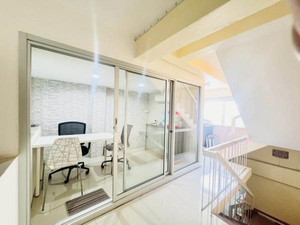 Shophouse for rent in Phra Khanong, Bangkok - Glass-enclosed office room beside an internal staircase with bright lighting.