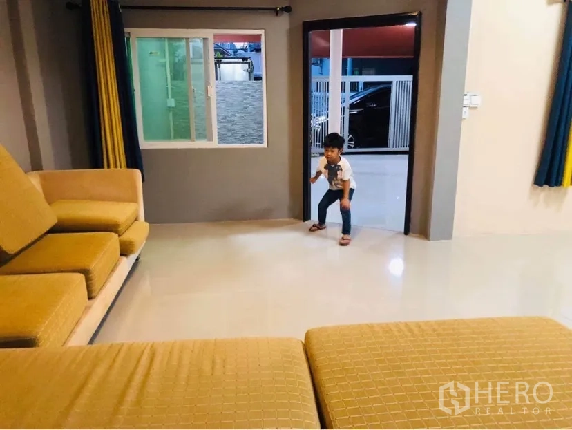 Townhouse for rent or sale in Huai Khwang, Bangkok - Open living area with sliding windows and doorway to the front terrace.