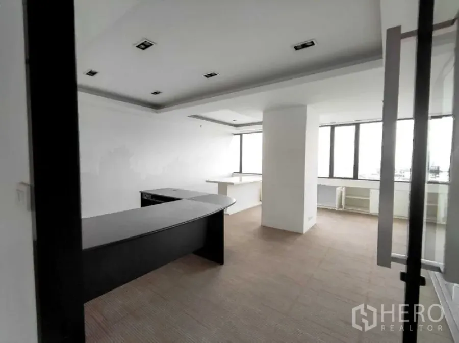 Office Space for rent in Ratchathewi, Bangkok - Private executive office with curved desk, carpet tiles, and large windows.