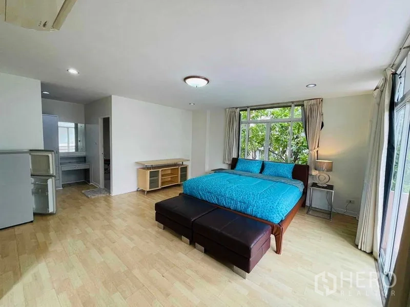 Detached House for rent in Watthana, Bangkok - Oversized bedroom with corner windows, balcony access, and bench seating.