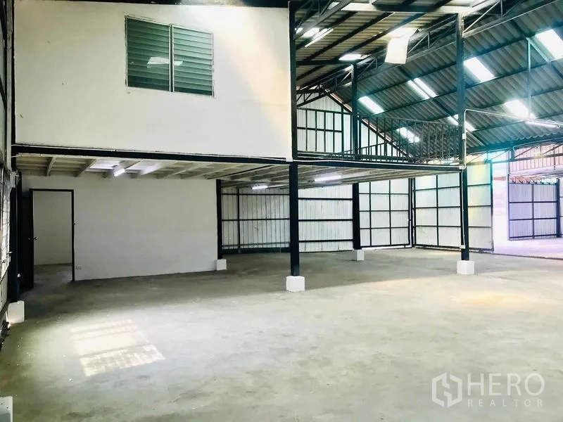 货栈 出租在Pathum Thani - 仓库内部，带夹层办公室、钢立柱和明亮天窗。