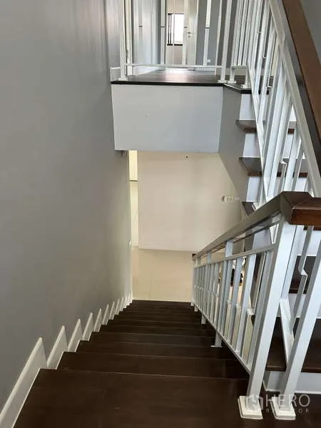 Detached House for sale in Lam Luk Ka, Pathum Thani - Wooden staircase with white railings viewed from above.