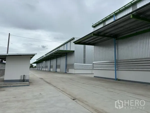 Warehouse for rent in Wang Noi, Phra Nakhon Si Ayutthaya - Row of metal warehouses with covered loading bays along a spacious internal driveway.