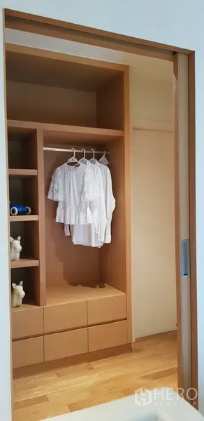 Condominium for rent in Khlong Toei, Bangkok - Built-in wooden wardrobe with shelves, drawers and sliding door.