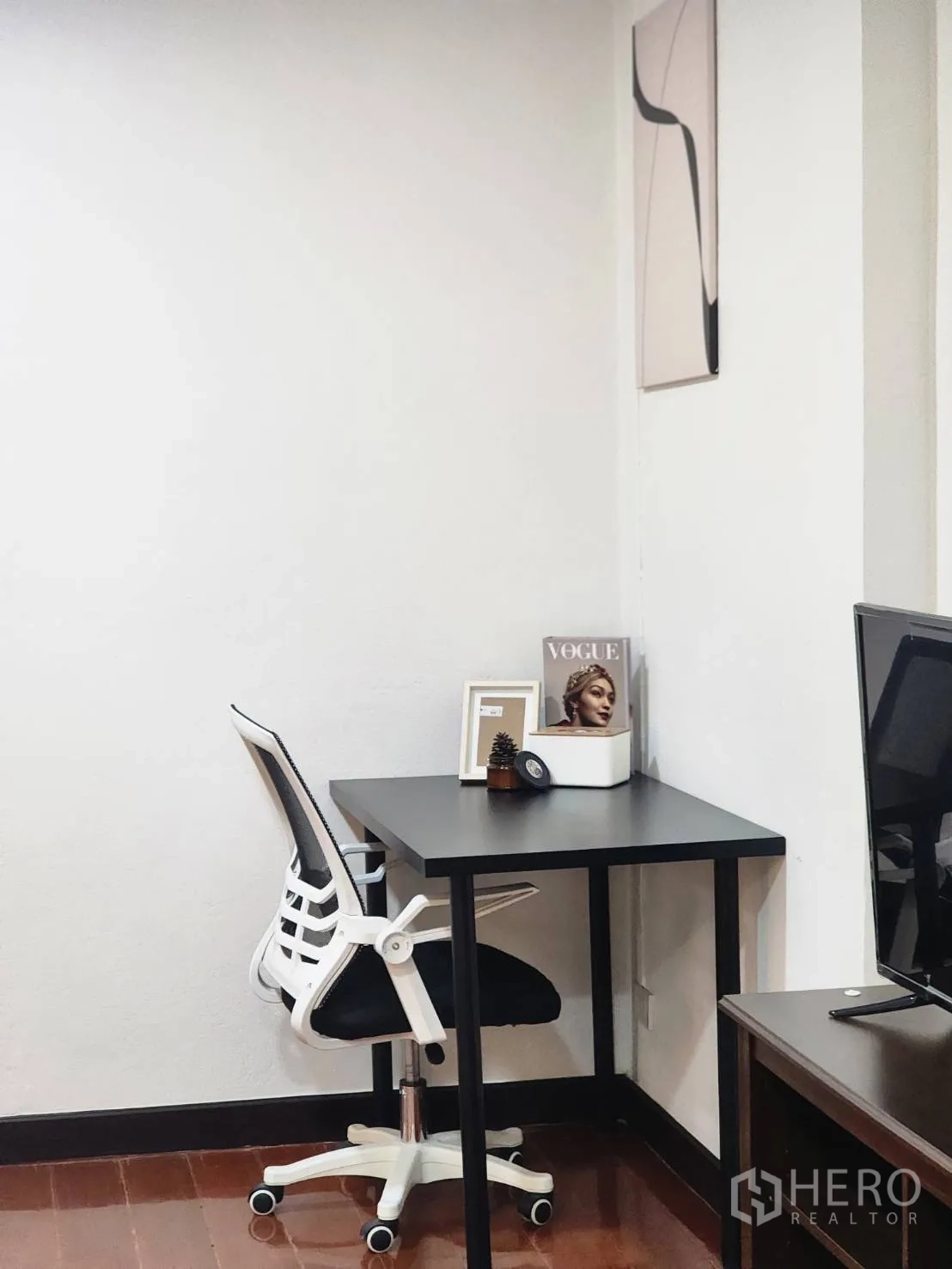 Detached House for rent in Huai Khwang, Bangkok - Minimal workspace with black desk and ergonomic chair near a TV stand.