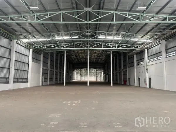 Factory for rent in Bang Sao Thong, Samut Prakan - Deep warehouse hall with high clearance and roof skylights for natural light.