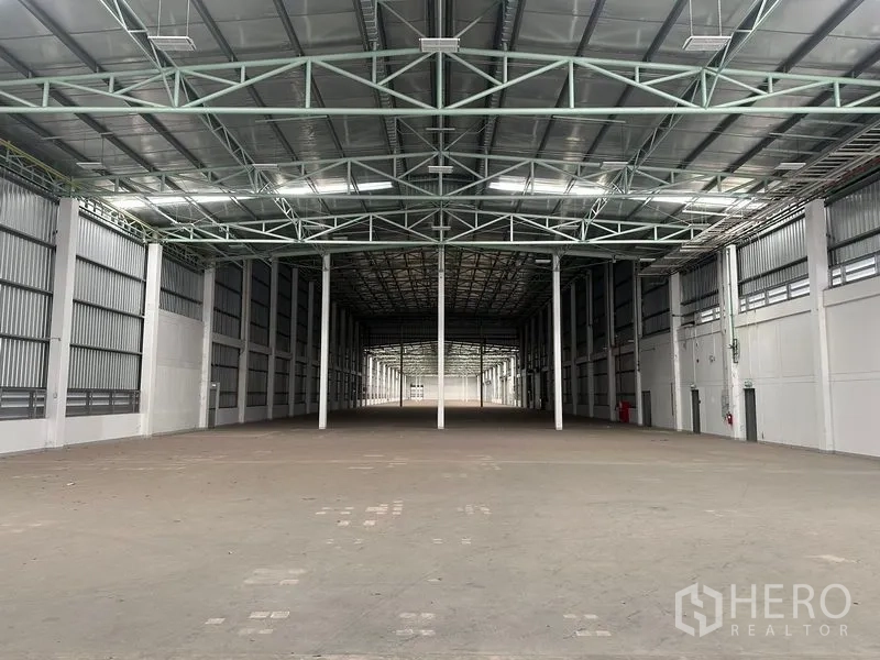 Factory for rent in Bang Sao Thong, Samut Prakan - Deep warehouse hall with high clearance and roof skylights for natural light.