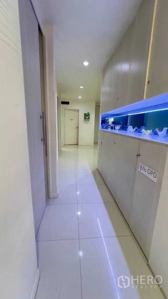 Standalone for rent in Khlong Toei, Bangkok - Long hallway with built-in cabinets and blue accent lighting.