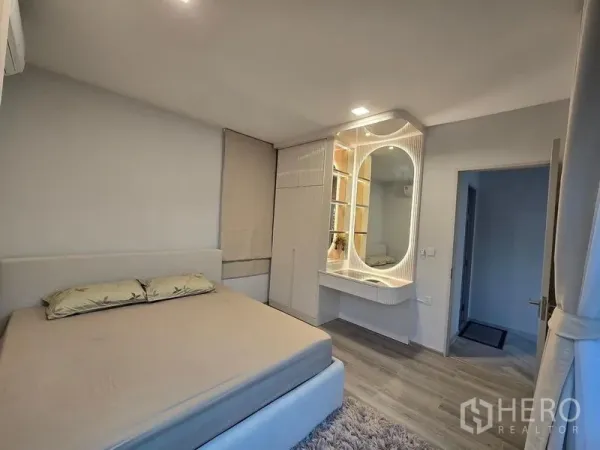 Detached House for rent in Bang Phli, Samut Prakan - Cozy bedroom with built‑in illuminated vanity, wardrobe cabinets and warm wood flooring.