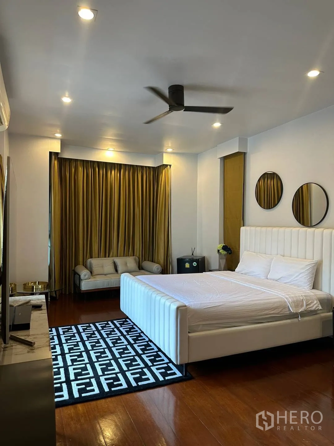 Detached House for rent in Watthana, Bangkok - Spacious bedroom with white bed, sofa corner and blackout curtains.
