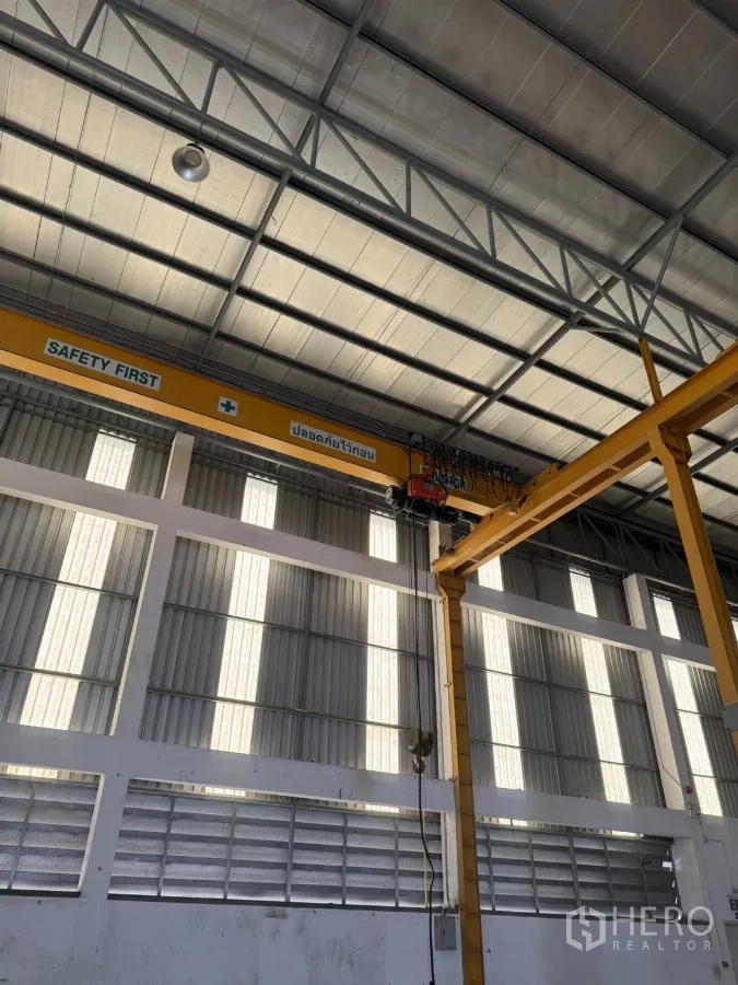 Factory for rent or sale in Bang Phli, Samut Prakan - Close-up of yellow overhead crane and steel roof trusses.