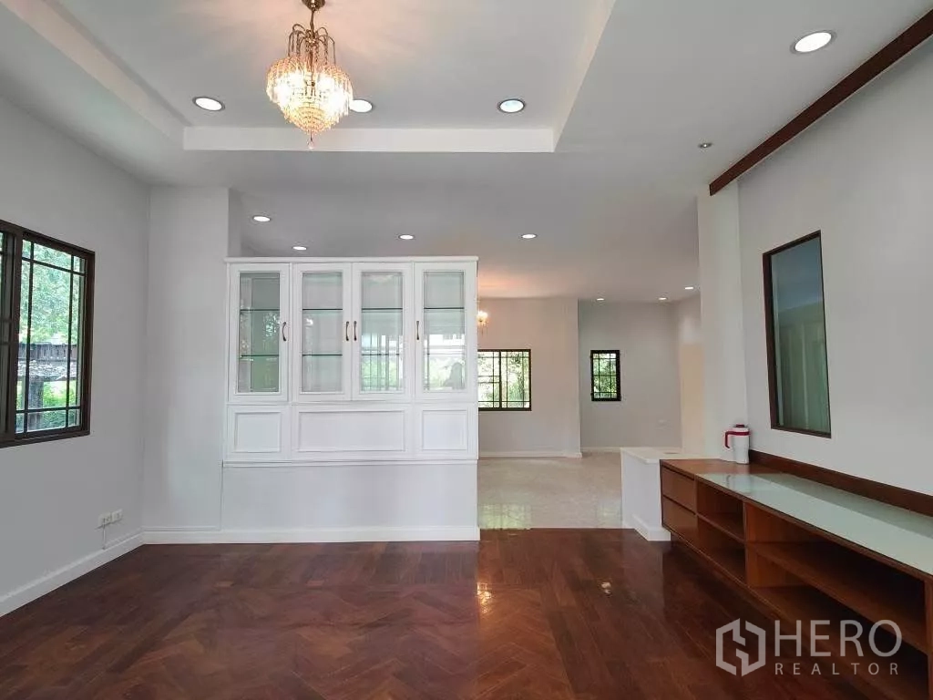 Detached House for rent or sale in Mueang Nonthaburi, Nonthaburi - Open-plan living space with white built-in display cabinet and recessed lighting.