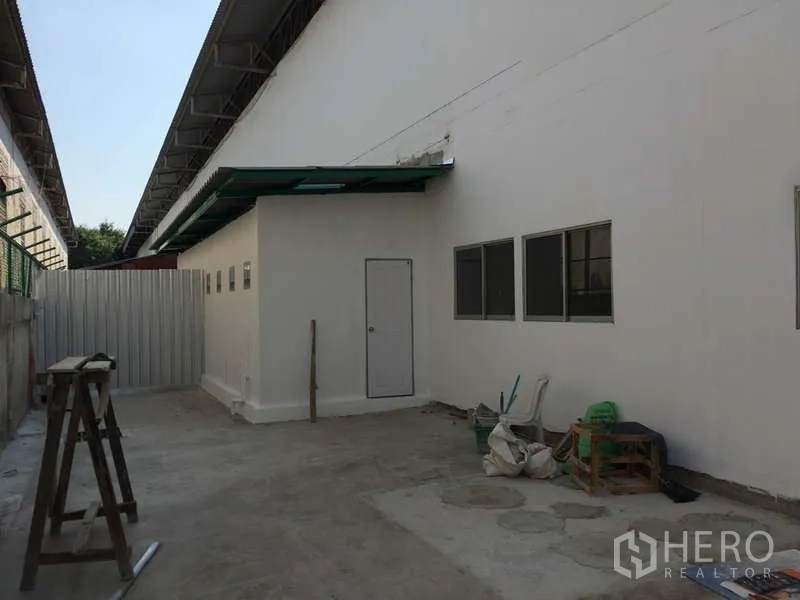 工厂 出租在Bang Bo, Samut Prakan - 后方服务庭院，侧门与窗户并设，带小雨棚通道。