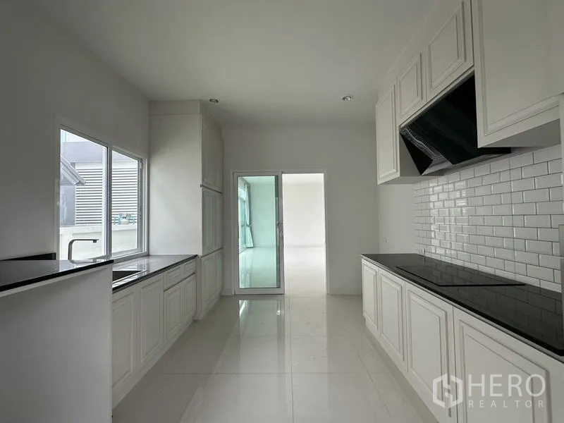 Detached House for sale in Lam Luk Ka, Pathum Thani - Kitchen view toward the sliding door that connects to the living area.