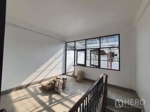 店屋 出租在Bangkok - 楼梯平台区，带大片格栅窗与金属栏杆，阳光充足