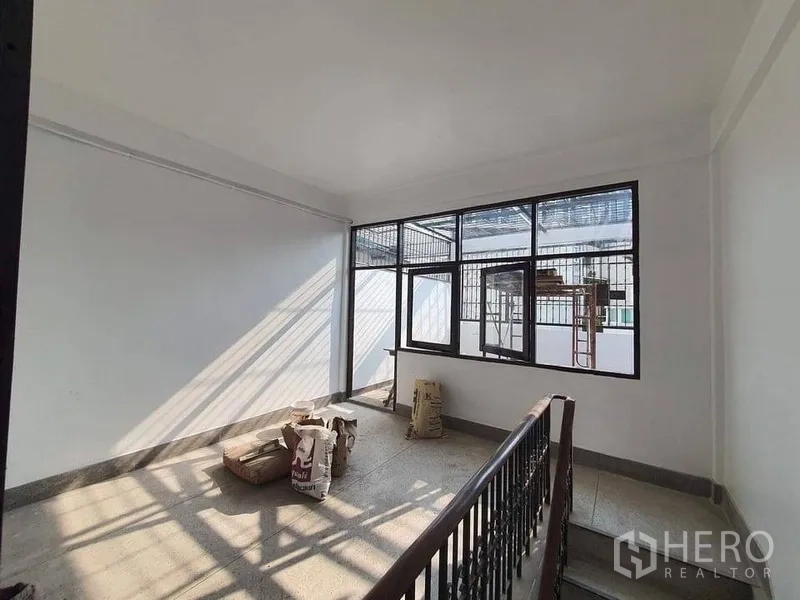店屋 出租在Bangkok - 楼梯平台区，带大片格栅窗与金属栏杆，阳光充足