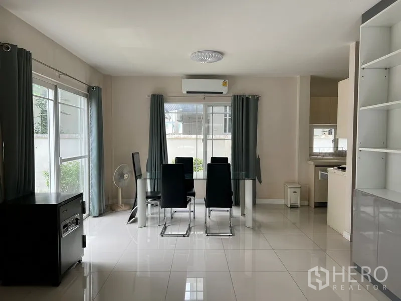 Detached House for rent in Bang Kapi, Bangkok - Dining zone with glass table and four chairs, open to the living room and garden views.