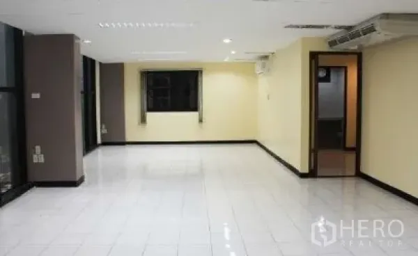 办公空间 出租在Bang Rak, Bangkok - 开放式办公区，白色地砖，吊顶灯，多个窗户与通往内室的门。