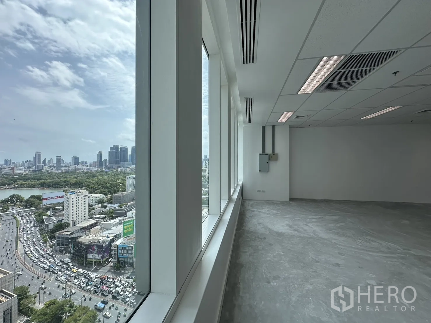 Office Space for rent in Watthana, Bangkok - High-floor office window line overlooking a busy cityscape with greenery and towers.