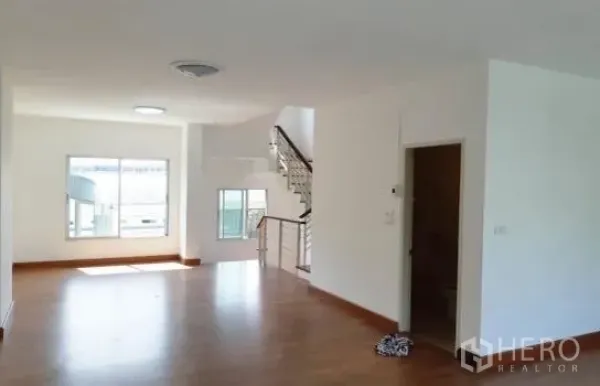 Home Office for rent in Wang Thonglang, Bangkok - Spacious open-plan floor with windows, wood flooring, and a staircase leading to upper levels.
