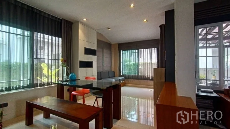 Detached House for sale in Prawet, Bangkok - Dining nook with glass table, bench seating and garden-view windows near the terrace.