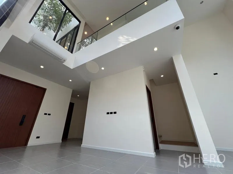 Home Office for sale in Phra Khanong, Bangkok - Mezzanine view of the foyer with glass balustrade and timber doors.