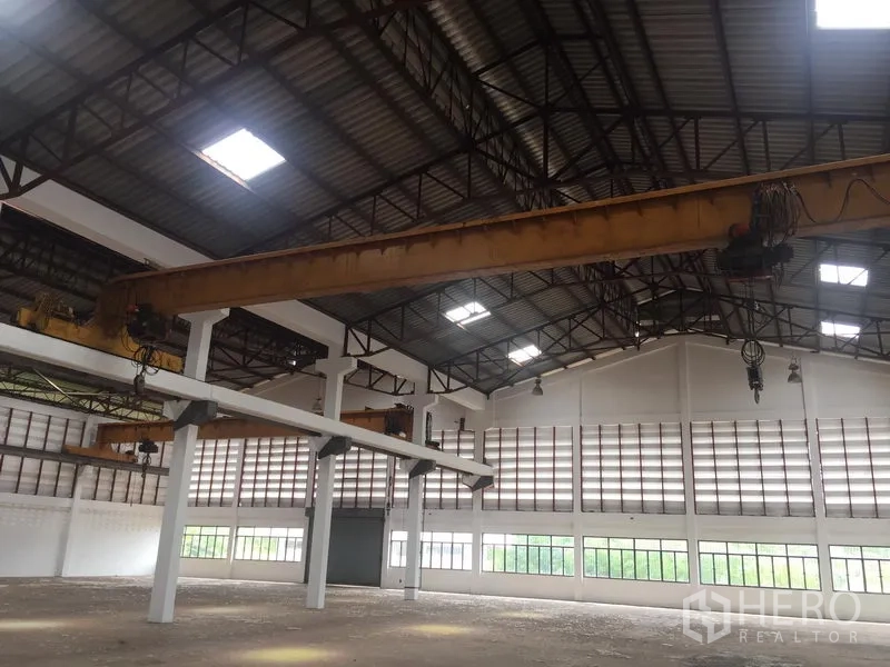 货栈 出租在Lam Luk Ka, Pathum Thani - 仓库内高顶下的行车吊，配宽幅进出门与四周窗户。