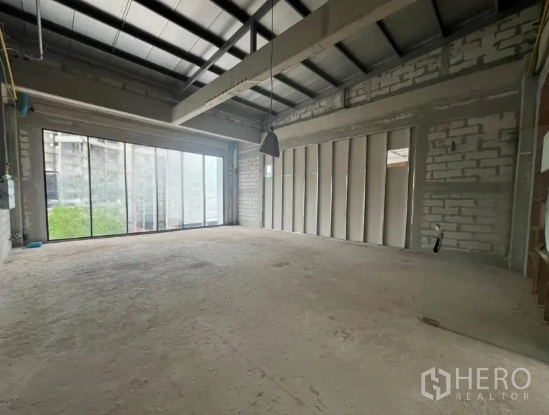 Retail Space for rent - Spacious retail space with high steel-beam ceiling, pendant light and sliding glass wall to natural light.