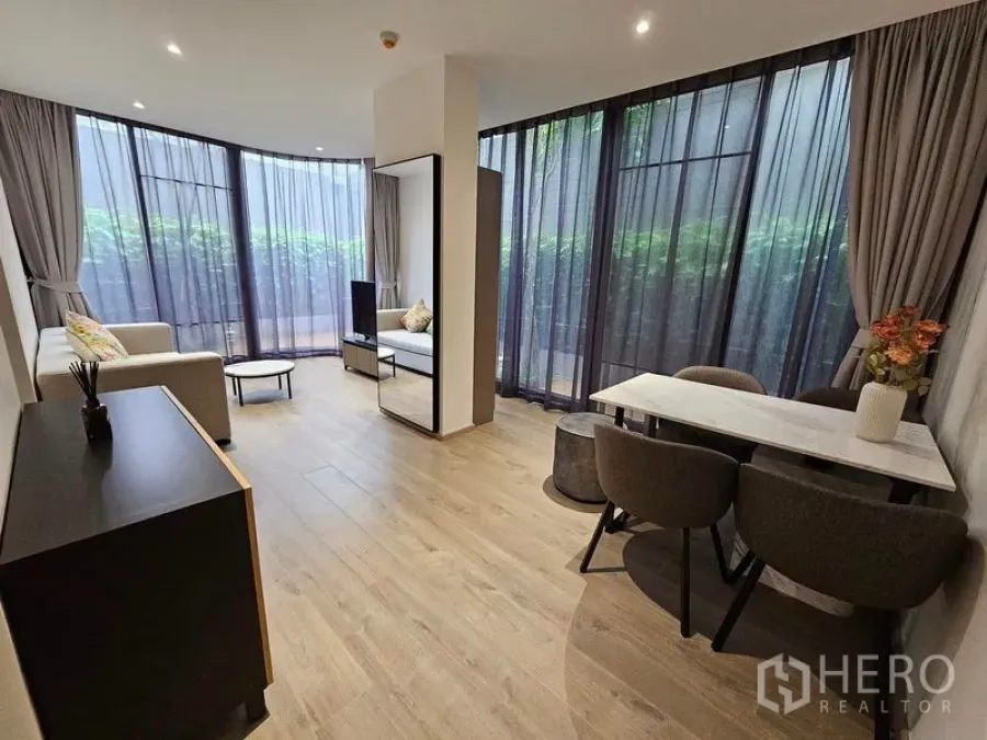 Condominium for rent or sale - Open-plan living and dining space overlooking the private terrace through tall glazing.