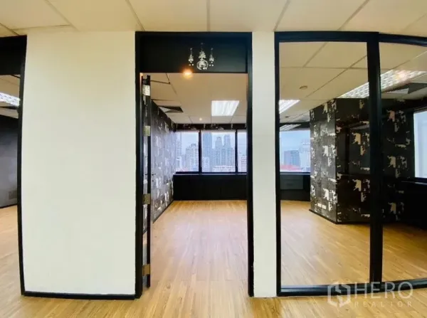 Office Space for rent or sale in Watthana, Bangkok - Glass-partitioned room opening to a bright office with city views and wood flooring.