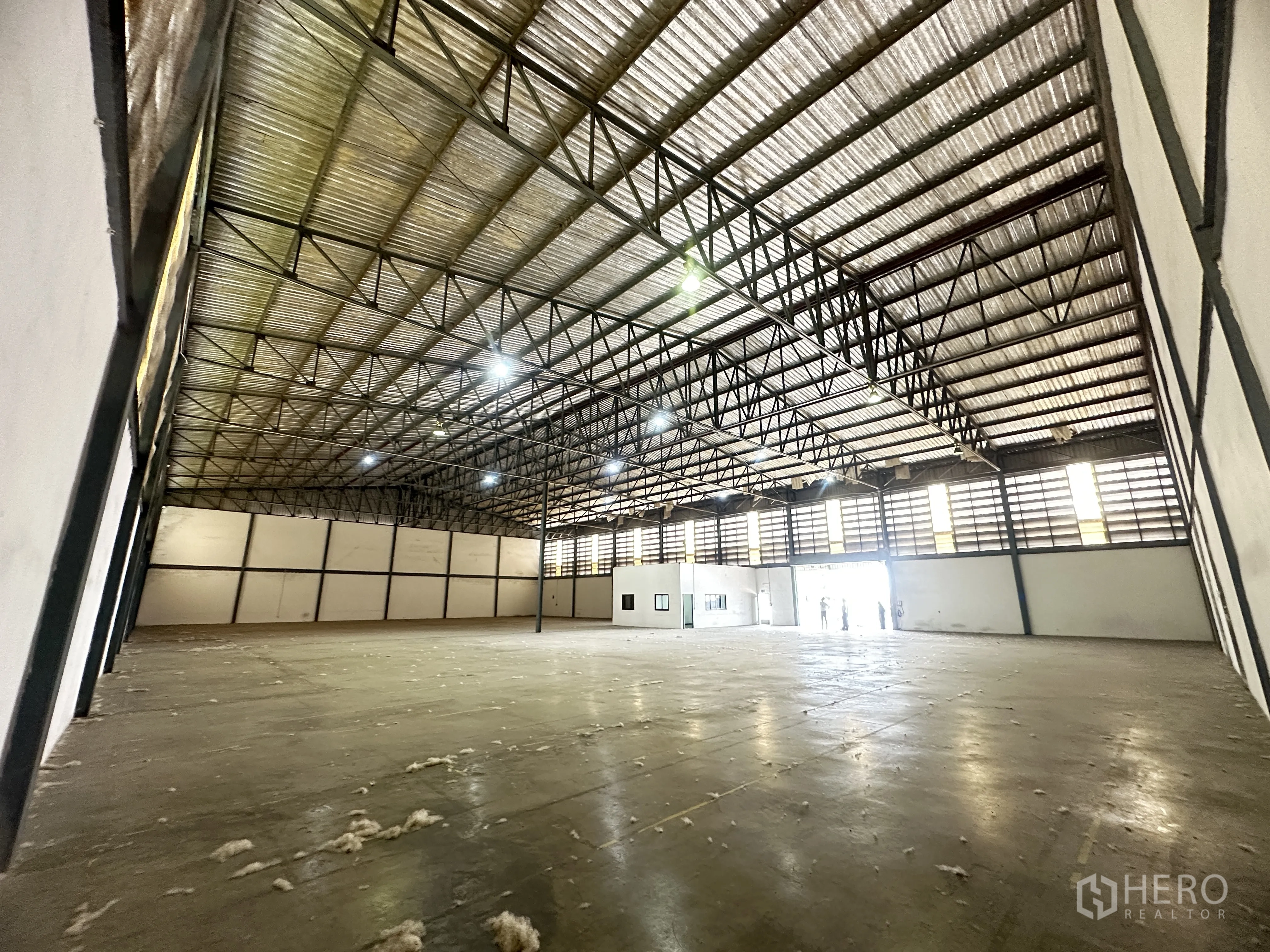 Warehouse for rent in Khlong Luang, Pathum Thani - Large storage hall with louvered windows and an entrance opening at the far end.