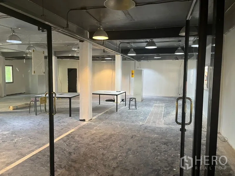 Retail Space for rent in Pathum Wan, Bangkok - Large shop space with pendant lighting, glass entry and work tables during fit-out.