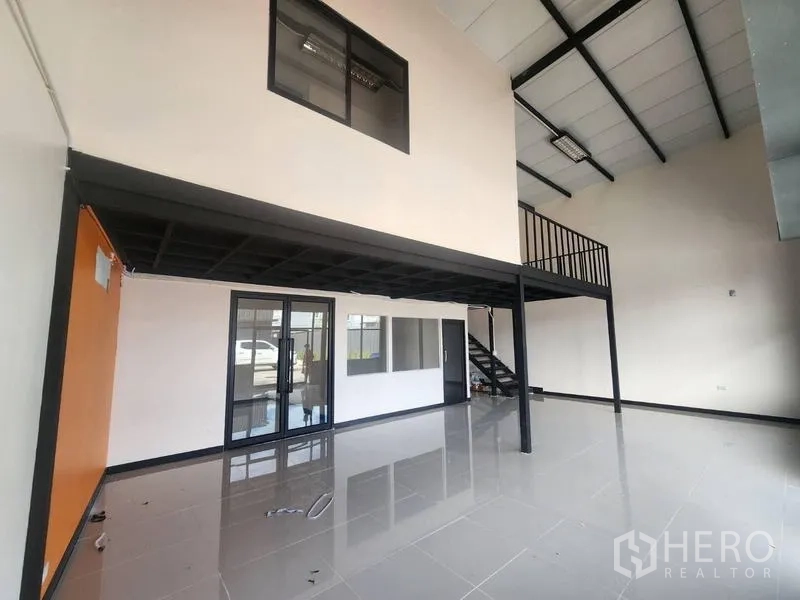 Warehouse for rent in Suan Luang, Bangkok - Main hall view toward the mezzanine with internal glass offices and stairs.