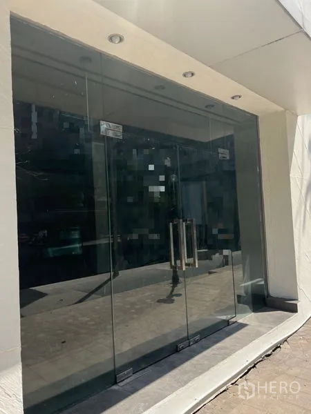 Retail Space for rent in Khlong Toei, Bangkok - Street-facing glass double doors and recessed lights at the retail storefront.