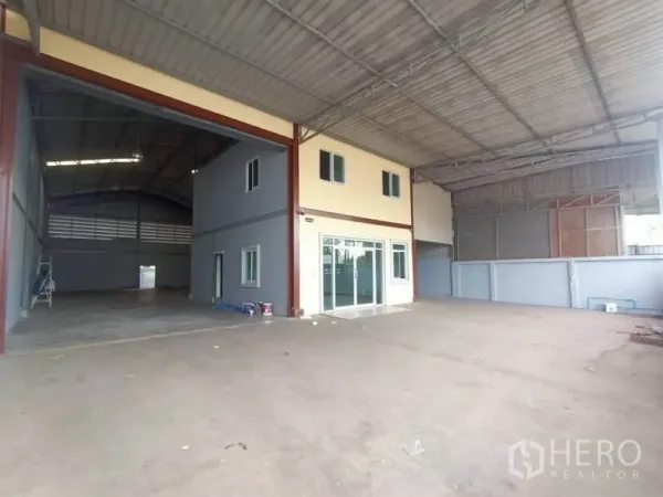 Factory for rent or sale in Mueang Samut Sakhon, Samut Sakhon - Covered loading bay with two-storey office block and large roller shutter entrance.