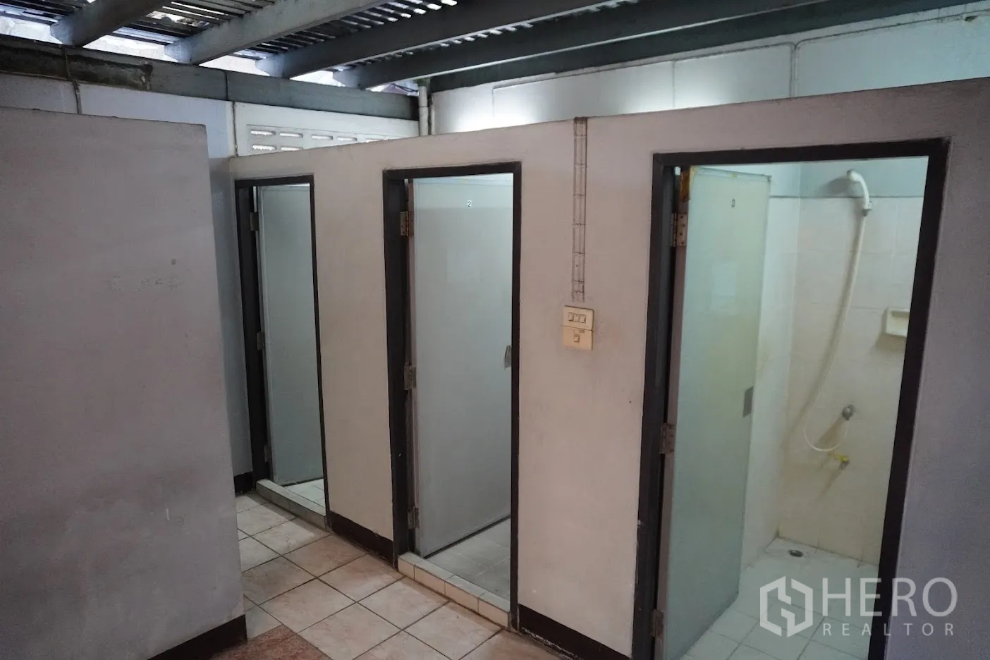 店屋 出租在Watthana, Bangkok - 一排淋浴间，磨砂玻璃门与瓷砖墙。