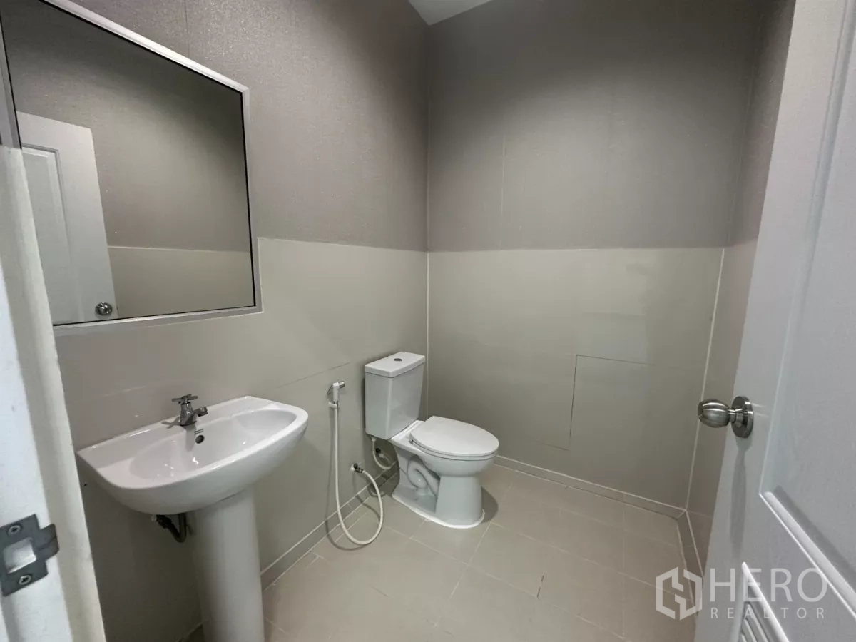 Factory for rent in Bang Phli, Samut Prakan - Bright restroom with pedestal sink and toilet.