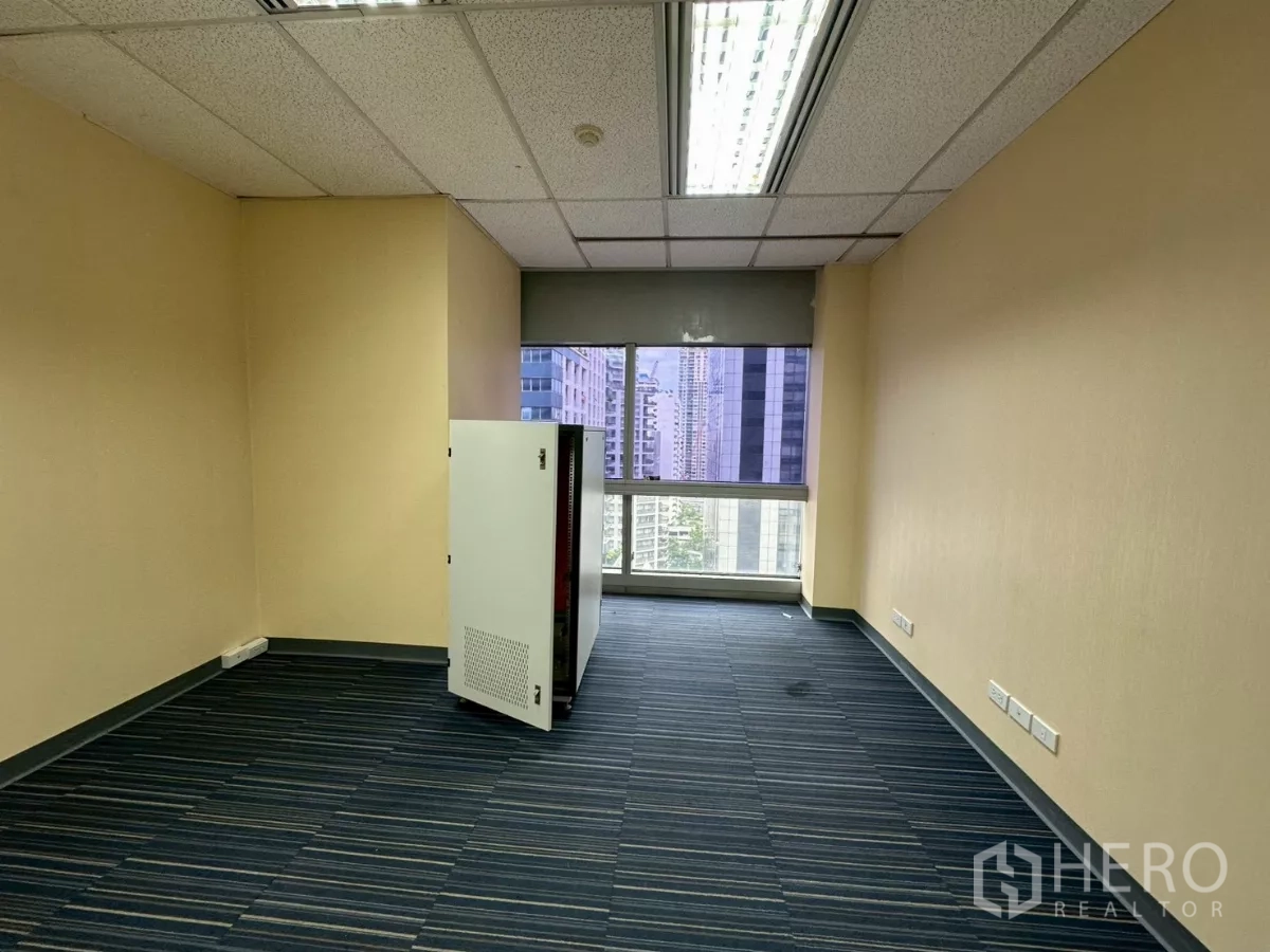 Office Space for rent in Watthana, Bangkok - Server or IT room with striped carpet, window and fluorescent lighting.