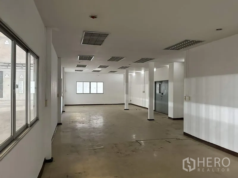 工厂 出租在Bang Bua Thong, Nonthaburi - 厂内成品办公室空间，带窗与格栅吊顶灯。
