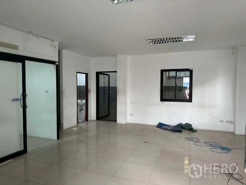Factory for rent or sale in Bang Phli, Samut Prakan - Ground-floor office inside the factory with tiled floor, white walls, and glass doors.