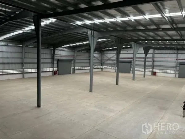Warehouse for rent in Nikhom Phatthana, Rayong - Elevated view of spacious warehouse floor showing clear column layout and high roof