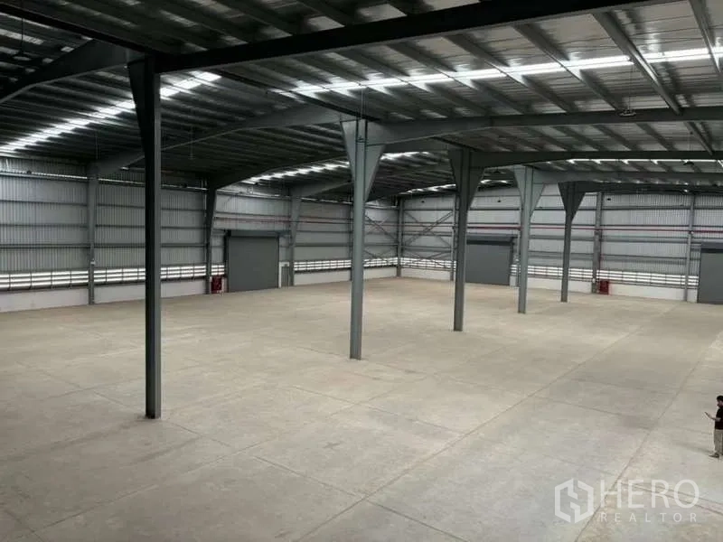 Warehouse for rent in Nikhom Phatthana, Rayong - Elevated view of spacious warehouse floor showing clear column layout and high roof