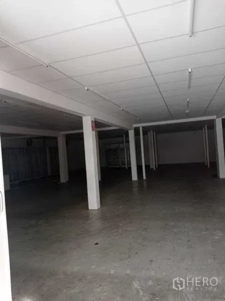 Warehouse for rent in Sathon, Bangkok - Large warehouse hall with grid ceiling, concrete flooring, and deep clear span for storage.