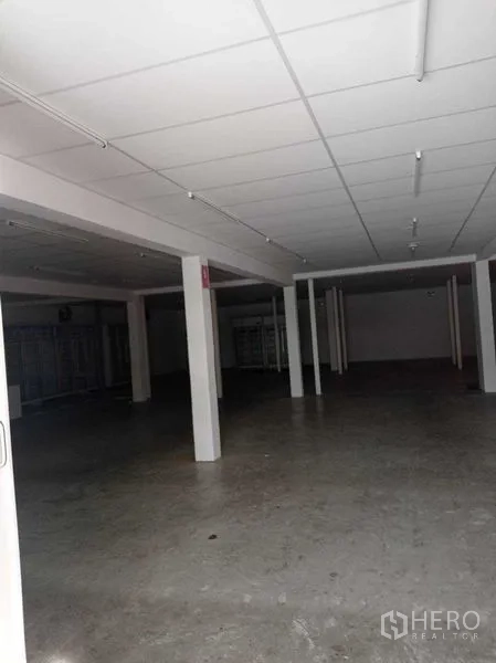 Warehouse for rent in Sathon, Bangkok - Large warehouse hall with grid ceiling, concrete flooring, and deep clear span for storage.
